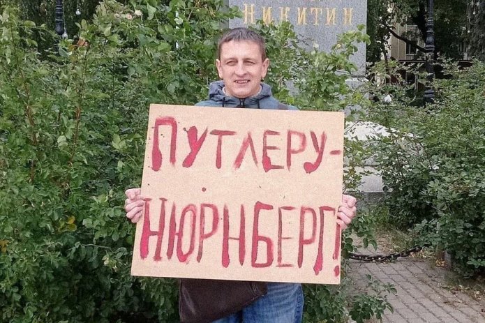 <em>Григорий Северин в одиночном пикете. За этот же плакат в январе 2021 года его <a href="https://glgpzcvu---mekodxpr-bsccljbcrq-ez.a.run.app/express-news/2021/01/20/voronezhca-arestovali-iz-za-odinochnogo-piketa-v-podderzhku-navalnogo"><u>арестовали</u></a> на пять суток (ч. 8 ст. 20.2 КоАП РФ) / Фото: Свободные Люди Воронежа</em>